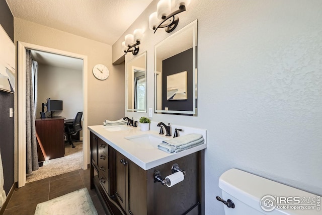 2447 E 100th Way, Thornton, CO 80229 - bathroom with tile patterned flooring, double vanity, toilet, and a textured wall