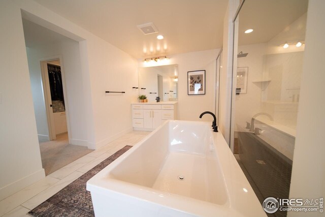 9415 E 58th Dr, Denver, CO 80238 - bathroom featuring vanity, a bath, a walk in shower, recessed lighting, and baseboards