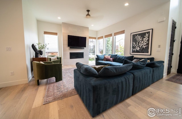 9415 E 58th Dr, Denver, CO 80238 - living area featuring light wood-style floors, a ceiling fan, baseboards, a fireplace, and recessed lighting