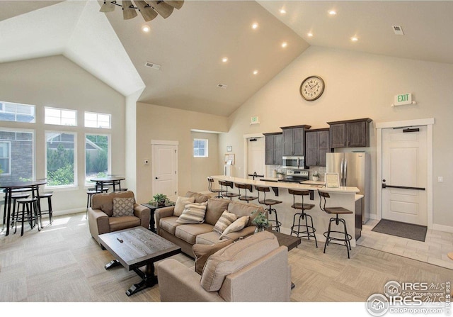 4642 Hahns Peak Dr Unit 101, Loveland, CO 80538 - living area featuring high vaulted ceiling, healthy amount of natural light, baseboards, recessed lighting, and a ceiling fan