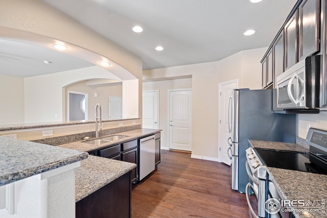 848 Shirttail Peak Dr, Windsor, CO 80550 - kitchen featuring appliances with stainless steel finishes, a sink, light stone countertops, dark wood-type flooring, and recessed lighting
