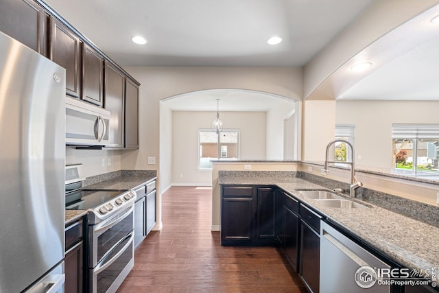 848 Shirttail Peak Dr, Windsor, CO 80550 - kitchen featuring appliances with stainless steel finishes, a sink, healthy amount of natural light, light stone countertops, and recessed lighting