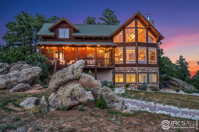 3309 Green Mountain Dr, Livermore, CO 80536 - back of property featuring stone siding, log siding, a deck, and a shingled roof