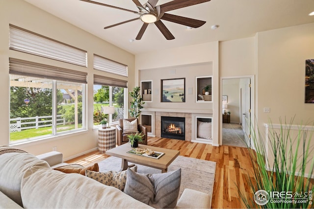 1427 Reeves Dr, Fort Collins, CO 80526 - living room with healthy amount of natural light, a tile fireplace, a ceiling fan, and light wood finished floors