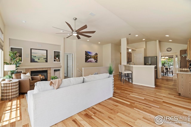 1427 Reeves Dr, Fort Collins, CO 80526 - living area featuring a fireplace, light wood finished floors, ceiling fan, recessed lighting, and high vaulted ceiling