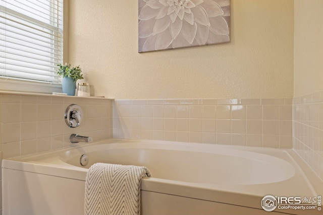 1427 Reeves Dr, Fort Collins, CO 80526 - bathroom featuring a garden tub and a textured wall