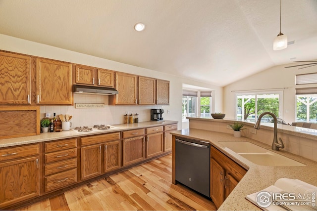 1427 Reeves Dr, Fort Collins, CO 80526 - kitchen with stainless steel dishwasher, a sink, under cabinet range hood, brown cabinets, and vaulted ceiling