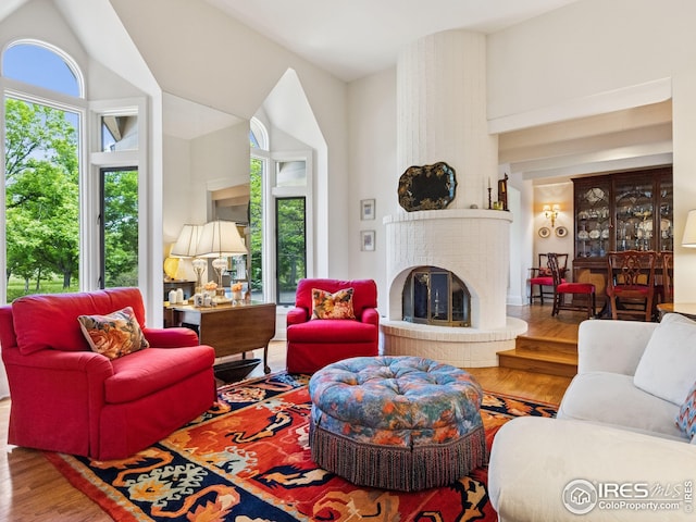 8000 N 41st St, Longmont, CO 80503 - living area featuring wood finished floors, a brick fireplace, and lofted ceiling