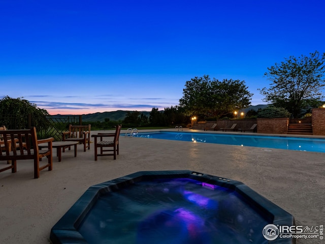 8000 N 41st St, Longmont, CO 80503 - pool at dusk with an in-ground hot tub and a patio area