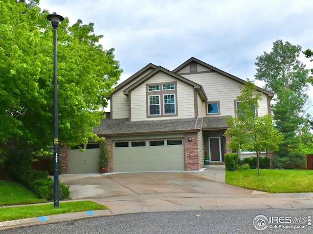 1477 Akers Ct, Erie, CO 80516 - view of front of home with brick siding, an attached garage, concrete driveway, a front lawn, and roof with shingles