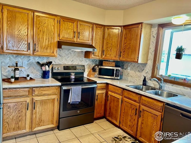 1722 Pheasant Rdg, Sterling, CO 80751 - kitchen with appliances with stainless steel finishes, under cabinet range hood, a sink, light countertops, and a textured ceiling