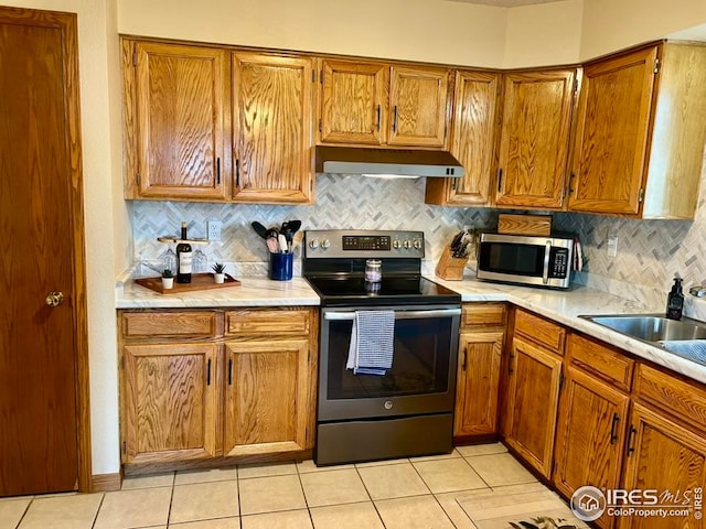 1722 Pheasant Rdg, Sterling, CO 80751 - kitchen featuring appliances with stainless steel finishes, under cabinet range hood, a sink, and light countertops