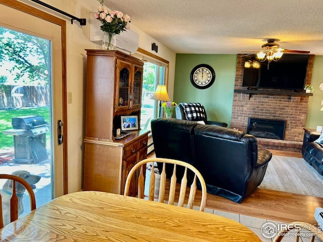 1722 Pheasant Rdg, Sterling, CO 80751 - dining space with a textured ceiling, wood finished floors, ceiling fan, and a brick fireplace
