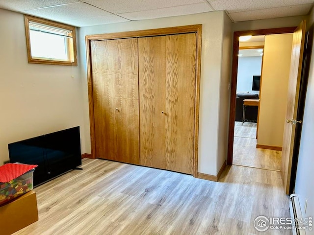 1722 Pheasant Rdg, Sterling, CO 80751 - unfurnished bedroom featuring wood finished floors, a closet, a baseboard heating unit, baseboards, and a drop ceiling