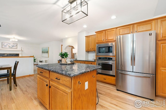 3514 Copper Spring Dr, Fort Collins, CO 80528 - kitchen featuring appliances with stainless steel finishes, a kitchen island, light wood-style flooring, dark stone counters, and recessed lighting