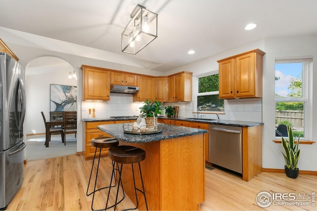 3514 Copper Spring Dr, Fort Collins, CO 80528 - kitchen featuring stainless steel appliances, a center island, tasteful backsplash, a breakfast bar, and light wood-style flooring