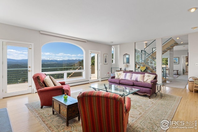 606 Sugarloaf Mountain Rd, Boulder, CO 80302 - living area featuring a baseboard heating unit, stairway, light wood-style flooring, and healthy amount of natural light