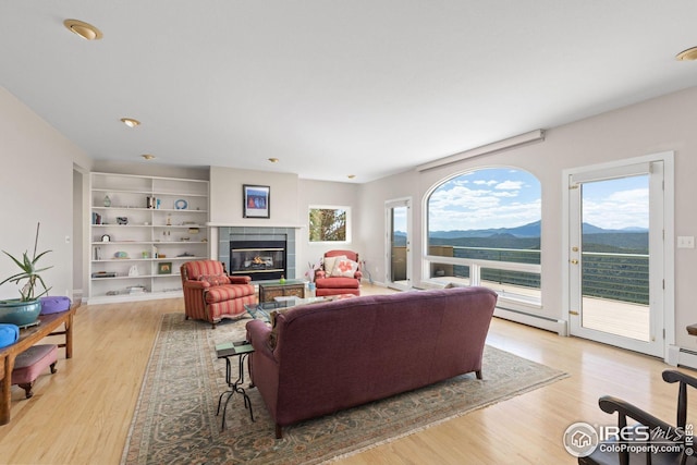 606 Sugarloaf Mountain Rd, Boulder, CO 80302 - living area with a mountain view, light wood finished floors, a tile fireplace, and a baseboard radiator
