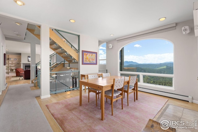 606 Sugarloaf Mountain Rd, Boulder, CO 80302 - dining room featuring a baseboard radiator, light wood-style floors, a mountain view, a fireplace, and recessed lighting