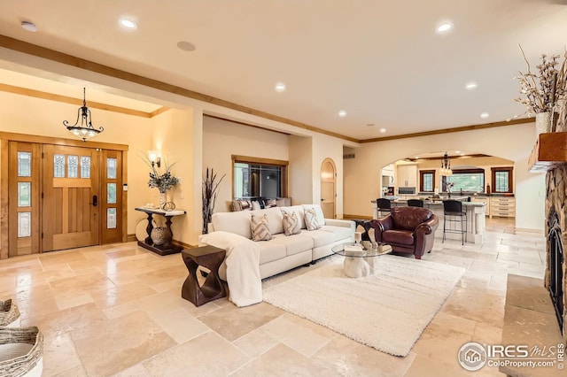 1570 County Road 37e, Lyons, CO 80540 - living area with arched walkways, stone tile floors, recessed lighting, crown molding, and a chandelier
