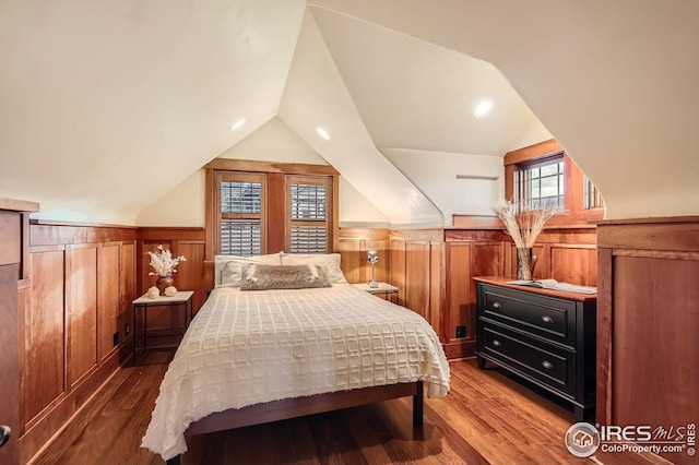 1570 County Road 37e, Lyons, CO 80540 - bedroom featuring a wainscoted wall, vaulted ceiling, and wood finished floors