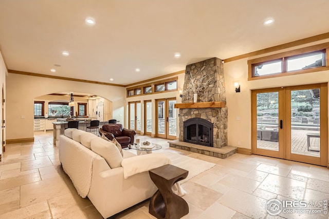 1570 County Road 37e, Lyons, CO 80540 - living room with arched walkways, french doors, stone tile floors, recessed lighting, and a fireplace