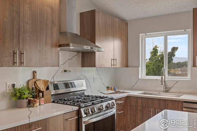2037 Spencer St, Longmont, CO 80501 - kitchen with stainless steel range with gas stovetop, wall chimney range hood, modern cabinets, light countertops, and a textured ceiling