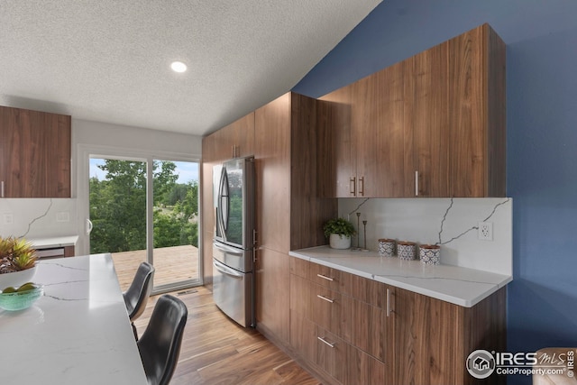 2037 Spencer St, Longmont, CO 80501 - kitchen featuring freestanding refrigerator, a textured ceiling, light wood-style floors, modern cabinets, and brown cabinets