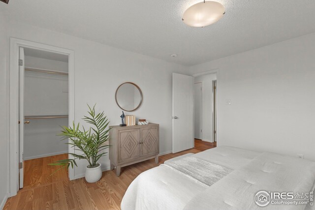 2037 Spencer St, Longmont, CO 80501 - bedroom featuring wood finished floors, a spacious closet, and a closet