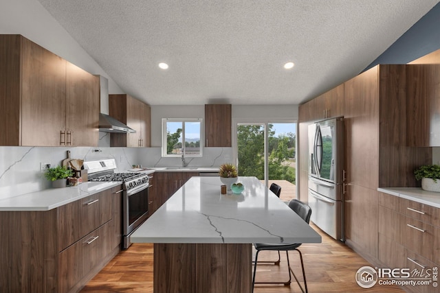 2037 Spencer St, Longmont, CO 80501 - kitchen featuring stainless steel appliances, modern cabinets, a breakfast bar, a textured ceiling, and a center island