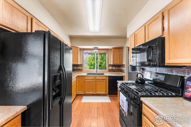 602 S 9th St, Berthoud, CO 80513 - kitchen featuring black appliances, light wood-type flooring, light countertops, decorative backsplash, and light brown cabinets