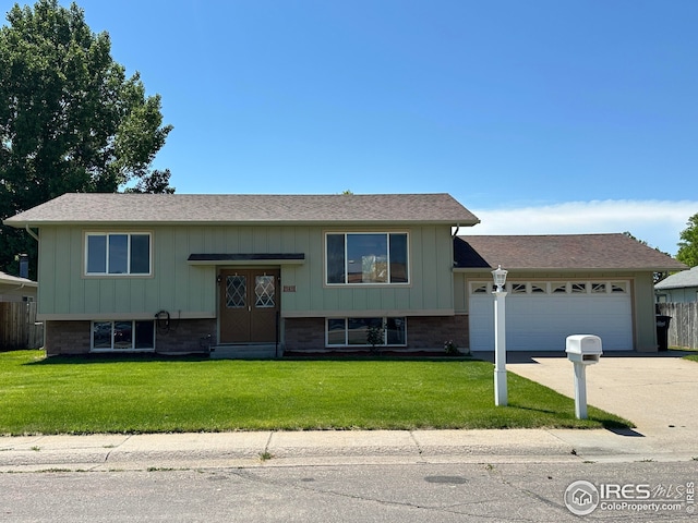 1410 S 8th Ave, Sterling, CO 80751 - split foyer home featuring an attached garage, driveway, brick siding, and board and batten siding