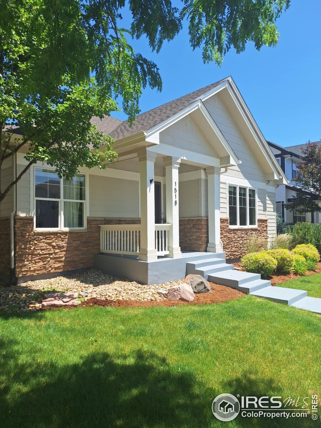 1518 Hollyberry St, Berthoud, CO 80513 - craftsman inspired home with stone siding, a porch, a front lawn, and a shingled roof