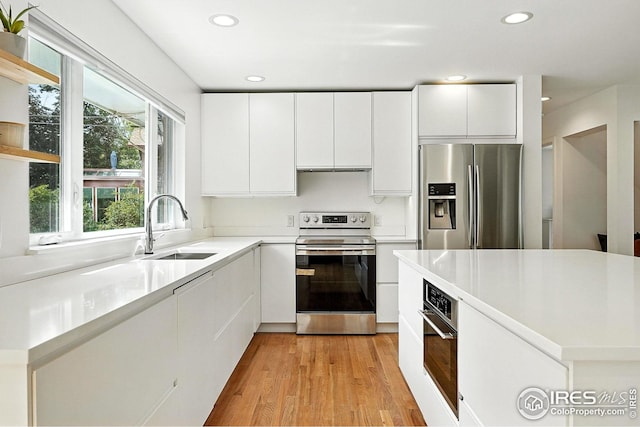 4545 Martin Dr, Boulder, CO 80305 - kitchen with appliances with stainless steel finishes, light wood finished floors, white cabinets, recessed lighting, and light countertops