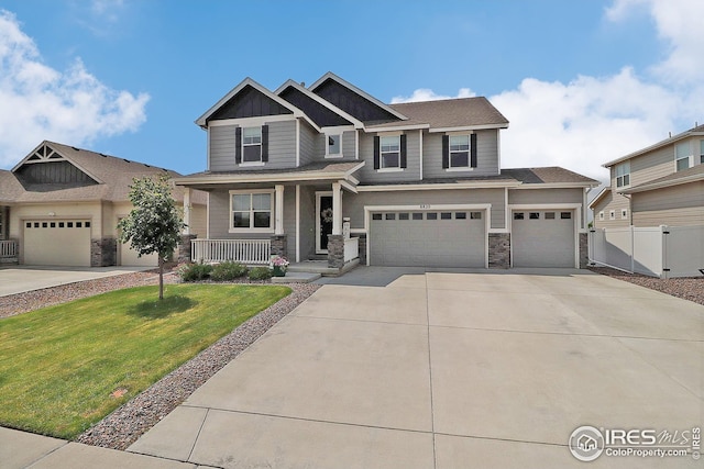 8820 14th Street Dr, Greeley, CO 80634 - craftsman-style house featuring a porch, concrete driveway, stone siding, and a garage