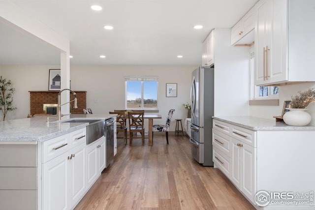 34288 County Road 59, Gill, CO 80624 - kitchen featuring stainless steel appliances, light wood-type flooring, white cabinetry, light stone countertops, and recessed lighting