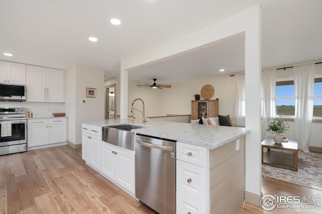 34288 County Road 59, Gill, CO 80624 - kitchen with appliances with stainless steel finishes, light wood-style flooring, light stone countertops, recessed lighting, and ceiling fan