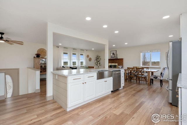 34288 County Road 59, Gill, CO 80624 - kitchen with appliances with stainless steel finishes, light wood finished floors, light stone counters, white cabinets, and recessed lighting