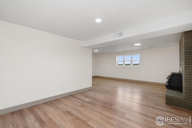 34288 County Road 59, Gill, CO 80624 - below grade area with a wood stove, light wood-style flooring, and recessed lighting