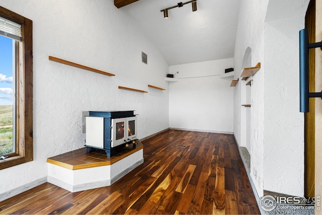 14975 US Highway 385, Julesburg, CO 80737 - unfurnished living room with a wood stove, vaulted ceiling, a textured wall, and hardwood / wood-style flooring