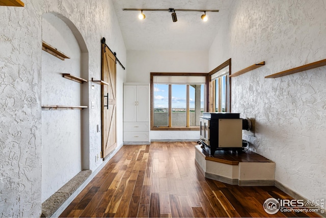 14975 US Highway 385, Julesburg, CO 80737 - unfurnished living room with a barn door, wood-type flooring, and track lighting