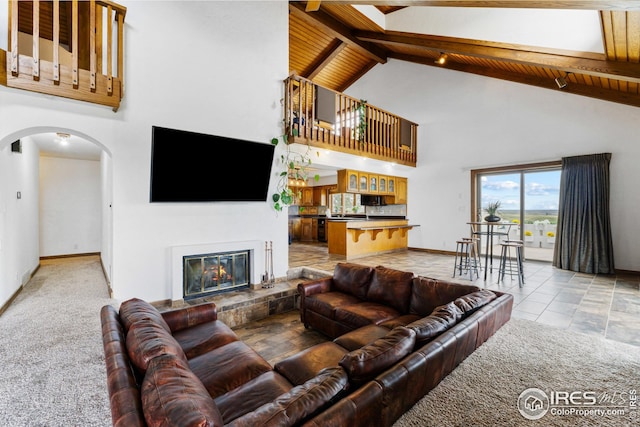 14975 US Highway 385, Julesburg, CO 80737 - living room with arched walkways, high vaulted ceiling, a wooden ceiling with exposed beams, and a glass covered fireplace