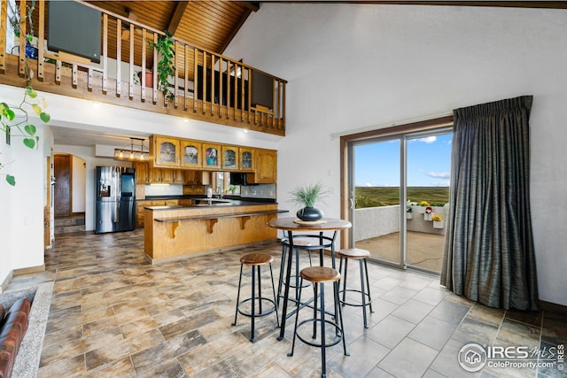 14975 US Highway 385, Julesburg, CO 80737 - kitchen with refrigerator with ice dispenser, a peninsula, dark countertops, arched walkways, and brown cabinetry