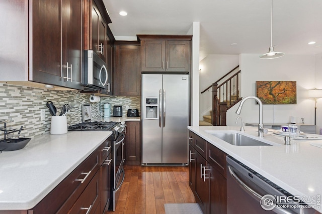 1944 Arapahoe Ave Unit A, Boulder, CO 80302 - kitchen featuring stainless steel appliances, light countertops, dark wood finished floors, decorative backsplash, and hanging light fixtures