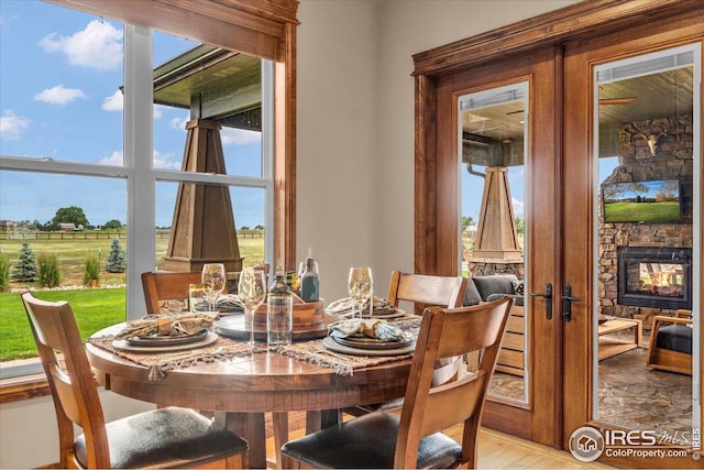 37021 Kingfisher Ct, Severance, CO 80550 - dining area with healthy amount of natural light, french doors, and a fireplace