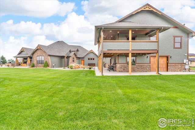 37021 Kingfisher Ct, Severance, CO 80550 - rear view of house with a patio area, a lawn, stone siding, and a sunroom