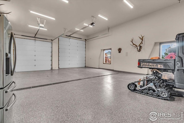 37021 Kingfisher Ct, Severance, CO 80550 - garage with stainless steel fridge with ice dispenser and a garage door opener