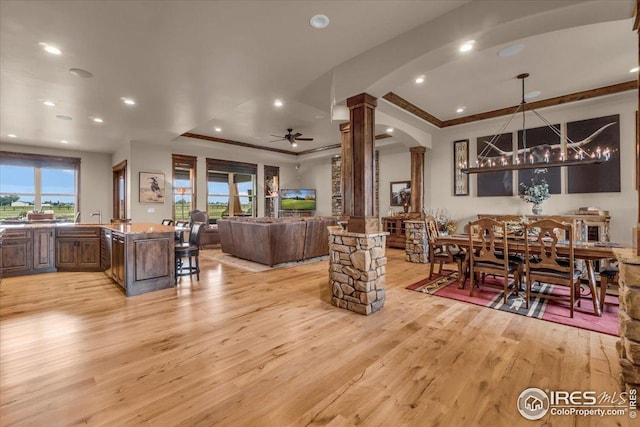 37021 Kingfisher Ct, Severance, CO 80550 - living area featuring decorative columns, a raised ceiling, arched walkways, light wood finished floors, and recessed lighting