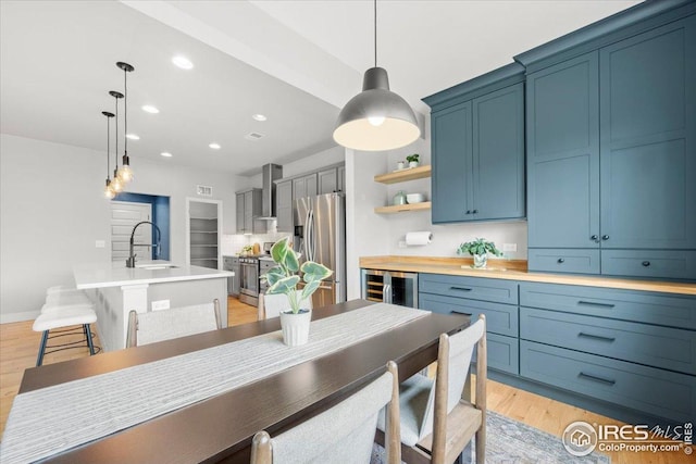 415 Stout St, Fort Collins, CO 80524 - kitchen featuring stainless steel appliances, wall chimney exhaust hood, wine cooler, open shelves, and light countertops
