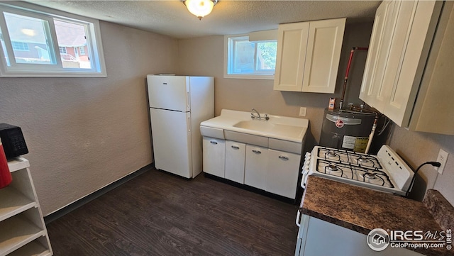 351 E 2nd St, Akron, CO 80720 - kitchen with white appliances, gas water heater, dark wood-style flooring, a textured ceiling, and white cabinetry